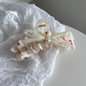 Detail of polka dot chiffon hair claw clip with bow and elegant pearl pendant