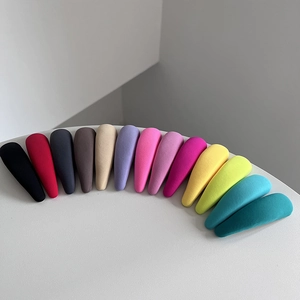Lot de 14 barrettes à cheveux colorées en tissu macaron disposées sur fond blanc