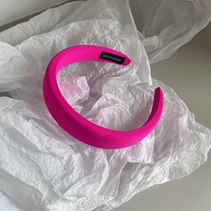 Detail of neon pink sponge headband with handmade fabric label on soft tissue paper