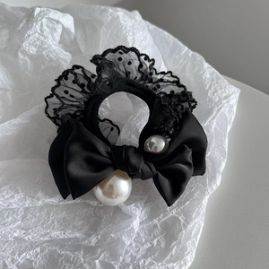 Close-up of black lace pearl hair tie with satin bow and polka dot detail