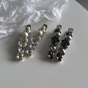 Elegant four-piece floral pearl and crystal hair clips set on minimalist gray background