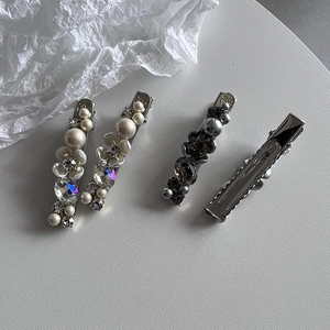 Elegant four-piece Korean style pearl and rhinestone flower hair clip set on a white surface