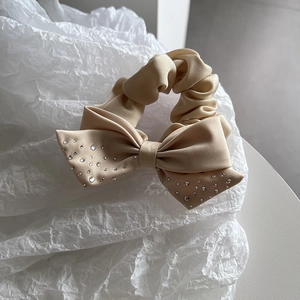 Beige satin silk scrunchie with large bow and sparkling rhinestones for elegant hairstyles