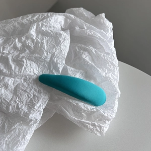 Détail de la barrette BB cyan montrant la texture du tissu tissé sur fond de papier blanc