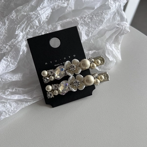 Detailed macro view of Korean style floral hair clips with pearls and crystals