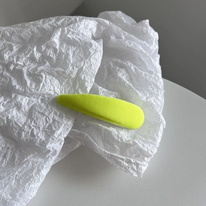 Détail macro d'une pince à cheveux jaune néon avec une texture textile de qualité