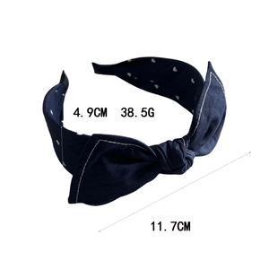 Serre-tête élégant en tissu bleu marine à motifs cœurs blancs avec un nœud papillon