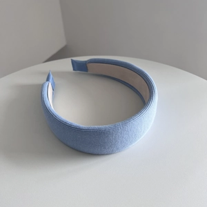 Detailed view of light blue ribbed fabric texture on a padded wide headband accessory