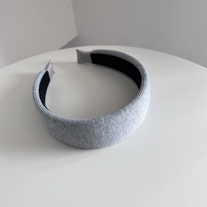 Close-up of gray knitted padded headband showing soft texture and anti-slip lining detail