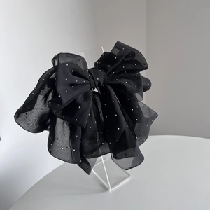 Detail of elegant black chiffon bow hair clip with sparkling silver rhinestones