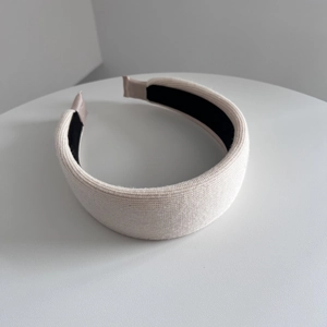 Detail of cream knitted wide headband with non-slip black lining and soft texture