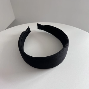 Dettaglio della trama del tessuto a coste nero su un cerchietto vintage imbottito largo