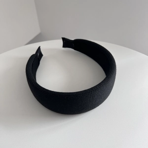Detail of black wide headband featuring ribbed knit fabric and thick padded sponge texture
