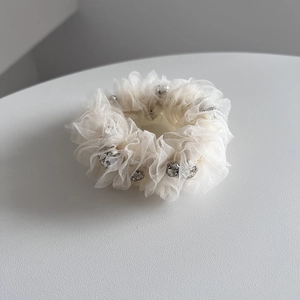 Detail of off-white seersucker hair scrunchie with sparkling silver rhinestone accents