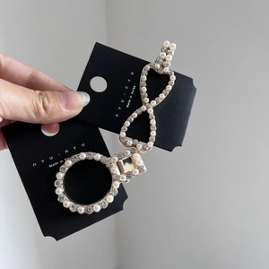 Elegant gold infinity and circular hair clips with pearls and rhinestones on card