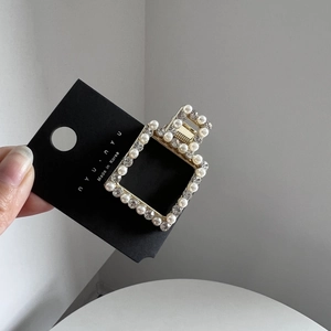 Detail of Korean gold hollow hair clip with white pearls and sparkling rhinestones