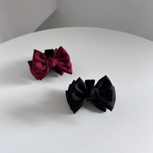 Elegant satin bow hair claw clips in burgundy and black set on a neutral background