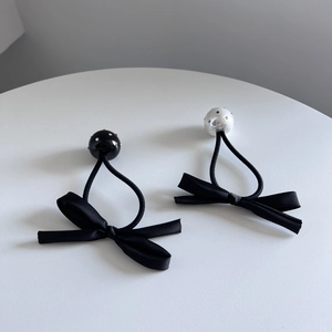 Elegante schwarze Haargummis mit Schleife, Perlen und Strass auf minimalistischem Grund