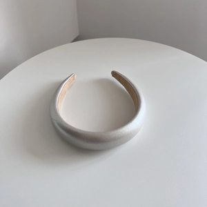 Close-up of padded silver headband with metallic finish and non-slip camel velvet lining