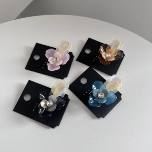 Fermagli per capelli a tre petali con strass in vari colori su schede espositive