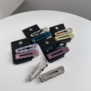 Set of wavy acetate resin hair clips in various marble colors on display card