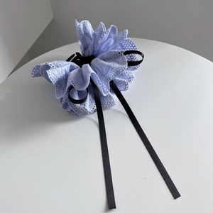 Gros plan sur un nœud en dentelle bleu clair avec rubans noirs et détails de tissage évidés
