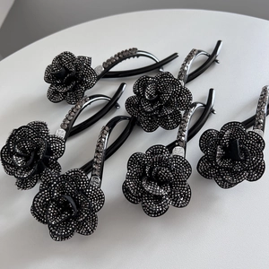 Elegant black camellia hair clip with shimmering rhinestones and metal finish