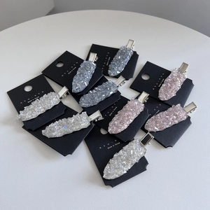 Elegant crystal duckbill hair clips in transparent blue and pink on white background