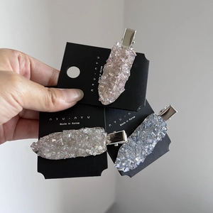 Close-up of sparkling crystal duckbill hair clips in champagne, white and blue sets