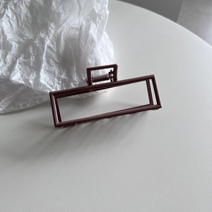 Detail of large rectangular hollow hair claw clip in deep coffee brown finish