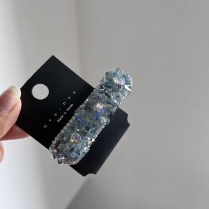 Dettaglio di fermaglio per capelli in cristallo con strass blu su carta nera