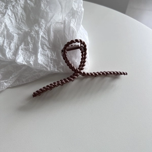 Detail of elegant mocha brown claw clip with textured twist design for secure hairstyling