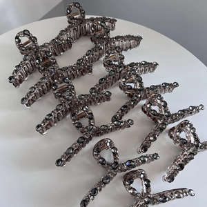 Dettaglio del fermaglio per capelli grigio fumo con strass scuri brillanti di lusso