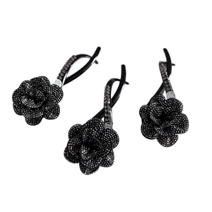 Three elegant black camellia hair clips with rhinestones and floral petals on white background