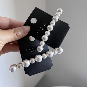 Paire élégante de barrettes à cheveux avec perles blanches sur base en métal doré