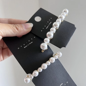 Détail de barrettes à perles de haute qualité avec base dorée sur carte de support