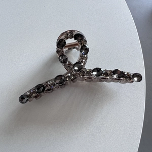 Dettaglio ravvicinato della molletta per capelli di lusso con cristalli grigio fumo