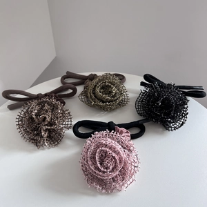 Détail de quatre chignons rose en tulle de couleurs marron, vert, noir et rose doux