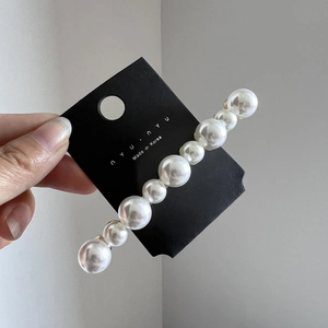 Gros plan détaillé de perles blanches élégantes sur une base de barrette à cheveux en métal