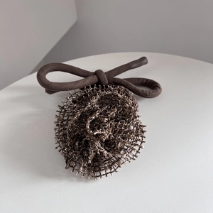 Détail de l'élastique à cheveux vintage avec fleur en tricot marron et nœud chic