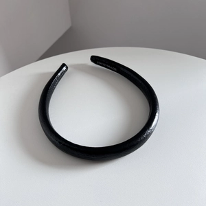 Détail d'un serre-tête en cuir noir avec texture litchi et logo intérieur fait main