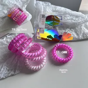 Detail of pink spiral phone cord hair ties in a branded box with sizing measurements