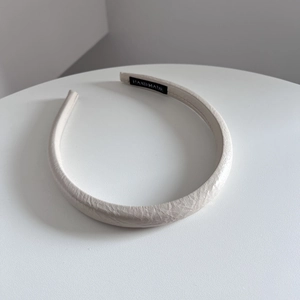 Vue détaillée du bandeau en cuir crème avec étiquette intérieure noire faite à la main