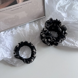 Close-up of black chiffon hair scrunchies with silver beaded edges for ponytail