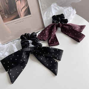 Detail of satin bow hair ties with heart print in black and dark red colors