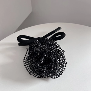 Gros plan détaillé d'un accessoire à cheveux en maille noire avec texture de fleur élégante