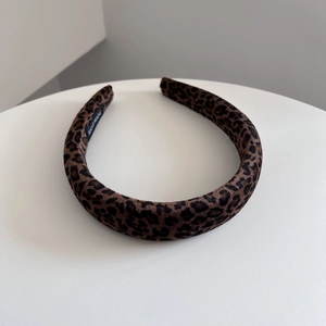 Dettaglio cerchietto in velluto leopardato con etichetta fatta a mano su bianco