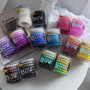 Eco-friendly TPU gradient spiral hair ties set in clear boxes on minimalist background