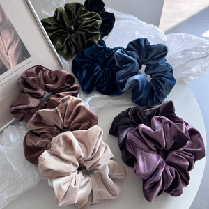 Set of multi-colored velvet scrunchies in elegant green, navy and champagne tones