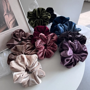 Set of 9 premium velvet hair scrunchies in assorted colors on an elegant white background